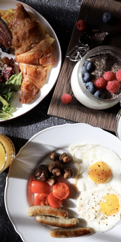 Breakfast plates with eggs, croissant, and yogurt parfait