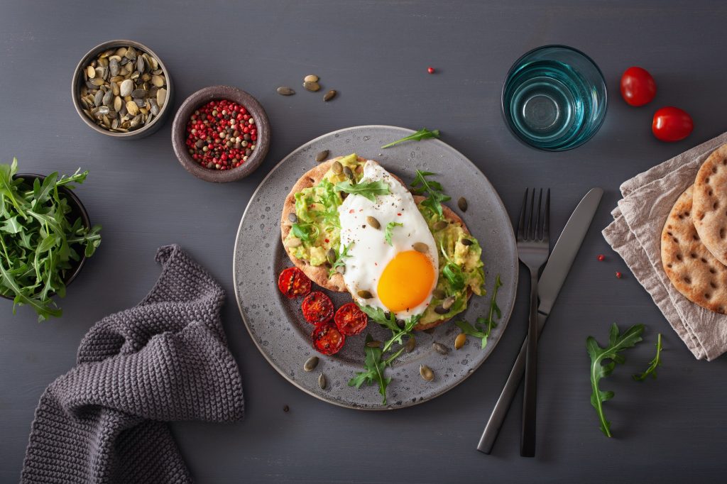 Avocado toast with fried egg and arugula